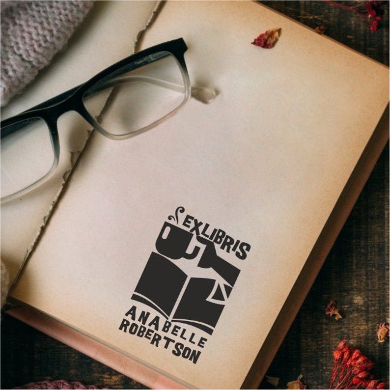 May include: A black and white bookplate with the text "Ex Libris" and "Anabelle Robertson". The bookplate features a stylized image of a book and a cup of coffee.