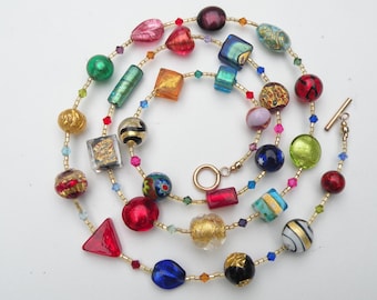 May include: A multi-strand necklace with gold beads and colorful glass beads in various shapes and sizes, including squares, circles, hearts, and triangles.
