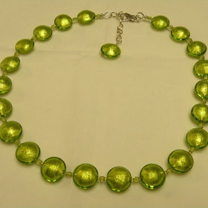 May include: A green glass bead necklace with a silver clasp. The beads are round and have a metallic sheen.