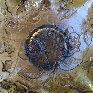 May include: A brown glass serving bowl with a scalloped edge and an embossed rose design.
