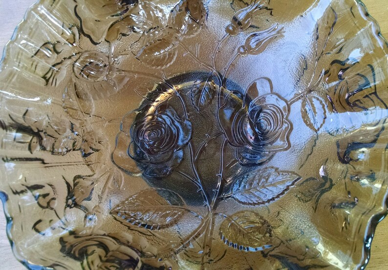 May include: A brown glass serving bowl with a scalloped edge and an embossed rose design.