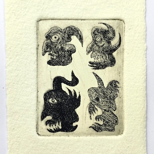Puede incluir: Una impresión en blanco y negro con cuatro caras de monstruos estilizadas con rasgos exagerados. La obra de arte está sobre un papel texturizado blanquecino. Cada cara tiene cuernos, dientes y detalles oculares únicos. El estilo recuerda a una linocut.
