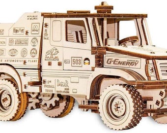 Könnte beinhalten: Ein Holzmodell eines Dakar-Rallye-Trucks mit detaillierten Merkmalen und sichtbarem Text, darunter "G-Energy" und "Dakar 2020". Das Modell ist hellbraun und hat große Räder und eine detaillierte Kabine.