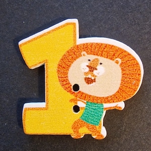 Peut inclure: Un numéro un en bois jaune avec un lion de dessin animé portant une chemise verte. Le lion est orange et brun avec un visage blanc.