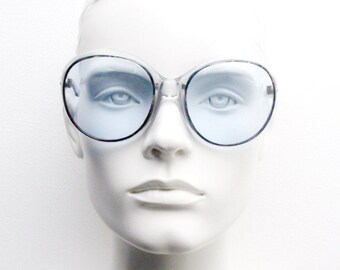 70s women's oversized vintage sunglasses made in France. Dramatic transparent frame with sky blue lenses