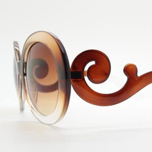 Y2K vintage oversized round sunglasses. Women's transparent brown and clear frame with gradient lenses and swirling arms. Unused NOS. 2000s