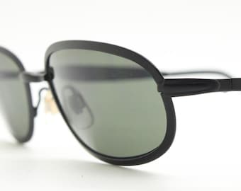 90's vintage black oval sunglasses made in Austria. Minimal matt finish solid metal flat frame with green lenses. Unworn  NOS