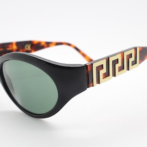 Carven Paris 90s vintage oval cat eye sunglasses. Womens black cateye frame with contrasting tortoise arms and awesome gold pattern. NOS