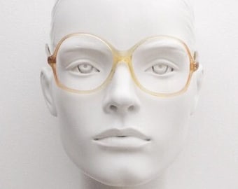 Puede incluir: Un par de gafas redondas de color ámbar con montura transparente.
