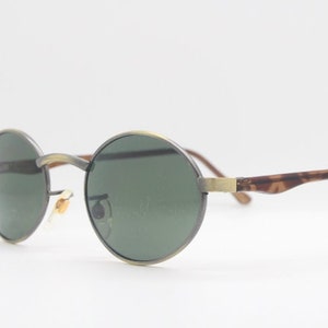 90s vintage oval sunglasses. Small satin bronze frame with green lenses and contrasting arms. Unused NOS. BNWT
