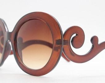 Y2K vintage oversized round sunglasses. Women's transparent brown frame with gradient brown lenses and swirling arms. Unused NOS. 2000s