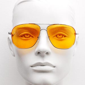 Gafas de sol de aviador vintage cuadradas de color naranja. Montura metálica de doble puente con cromo plateado y lentes de color naranja brillante. Gafas de aviador para hombre con diseño de los años 70.