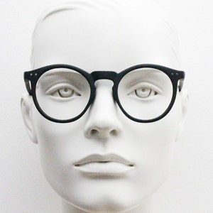 May include: A white mannequin wearing black round-framed glasses.