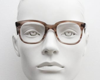 May include: A white mannequin head wearing brown tortoiseshell eyeglasses with a clear lens.