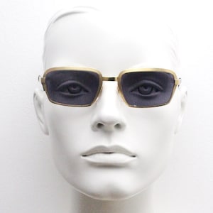 Neostyle original 60er Jahre Vintage Sonnenbrille rechteckig. Hochglanz-matt satiniert, schmaler goldfarbener Rahmen mit schwarzen Linsen. Psychedelisch mod