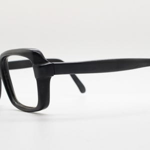 May include: Black plastic framed eyeglasses with a rectangular lens shape.