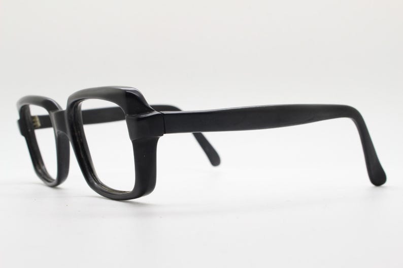 May include: Black plastic framed eyeglasses with a rectangular lens shape.