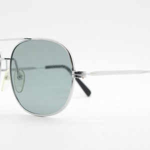 May include: Silver aviator sunglasses with gray lenses and black arms.