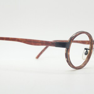 May include: Brown tortoiseshell eyeglasses with round black metal frames.