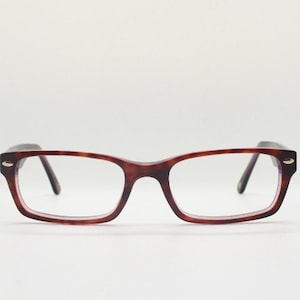 May include: A pair of tortoiseshell spectacles with a rectangular frame.