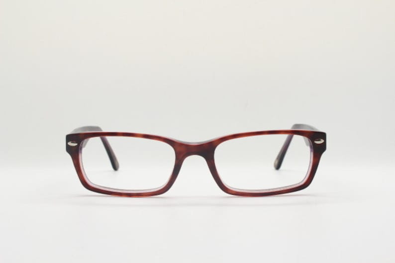 May include: A pair of tortoiseshell spectacles with a rectangular frame.