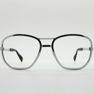 May include: Silver aviator style eyeglasses with black frames and clear lenses.