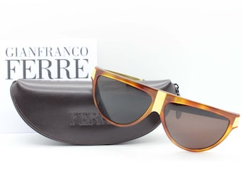 Occhiali da sole vintage Gianfranco Ferré anni '90 modello 26 405 realizzati in Italia. Montatura piatta in acetato marrone screziato con aste dorate e lenti marroni.