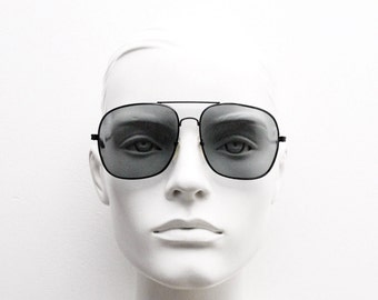 Óculos de sol aviador quadrados vintage dos anos 70. Armação de metal preto ligeiramente oversized com lentes escuras. Óculos de sol aviador masculinos originais dos anos 70, estilo gota.