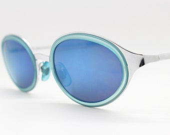 90's vintage oval sunglasses with silver metal frame encasing aquamarine insets and blue mirror lenses. NOS