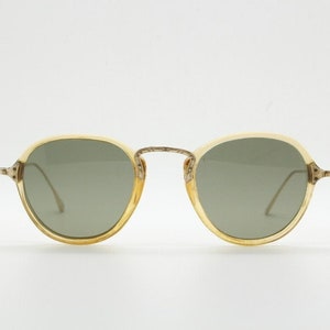 20er Jahre Vintage runde antike Sonnenbrille. Transparente Linseneinfassungen mit schlanken Armen und kunstvoll geprägtem Art Deco Metallsteg. 30er Jahre. Steampunk