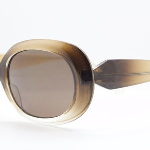90s vintage oval brown sunglasses. Dense lustrous 60&#39;s mod style frame with gold highlights. Unused NOS