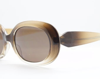 90s vintage oval brown sunglasses. Dense lustrous 60's mod style frame with gold highlights. Unused NOS