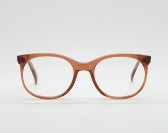 Puede incluir: Un par de gafas redondas de color marrón con lentes transparentes.
