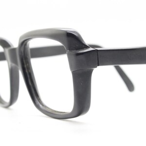 May include: Black plastic framed glasses with a square lens shape.