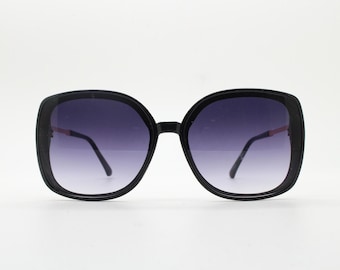 Damskie okulary przeciwsłoneczne w stylu vintage z lat 70., w kwadratowym, oversize'owym stylu Y2K, z czarną oprawką, złotymi metalowymi zausznikami i stopniowanymi soczewkami. Lata 2000.