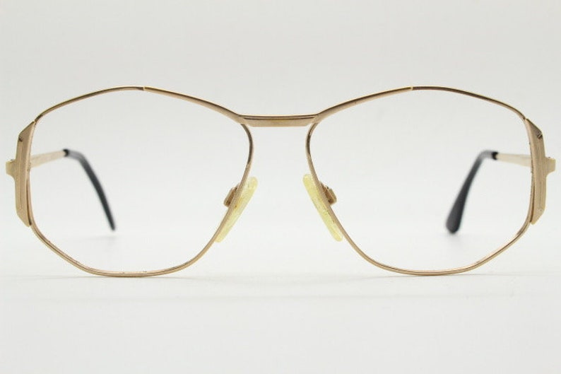 Puede incluir: Gafas de metal doradas con montura octogonal geom&eacute;trica y lentes transparentes.