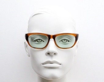 60er Jahre eiskalte Killer-Vintage-Sonnenbrille. Umlaufender Rahmen aus honigbraunem Acetat mit hellen, grünen Echtglasgläsern. Hells Angel Katzenauge