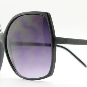 Puede incluir: Gafas de sol negras de gran tama&ntilde;o con montura cuadrada y lentes de color morado oscuro.