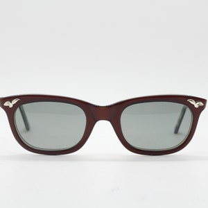 60s vintage womens cat eye sunglasses made in the UK. Pearlised acetate burgundy cateye frame with convex lenses. 50s rockabilly pin up