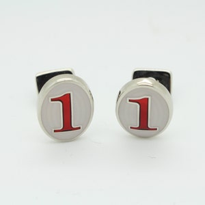 Vintage oval cuff links made in England by Herringbone. Solid metal construction with metallic red number 1. NOS