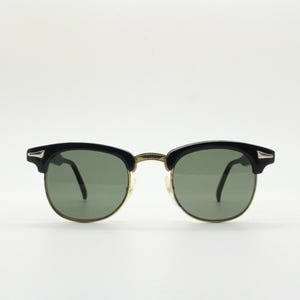 Vintage Sonnenbrille aus den 80er Jahren für Kinder. Schwarze Brauenlinie im Stil der 50er und 60er Jahre klassisches Halbgestell mit grünen Gläsern. Kinderwagenkette