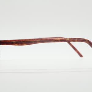 May include: A pair of tortoiseshell spectacles with black accents on the frame.
