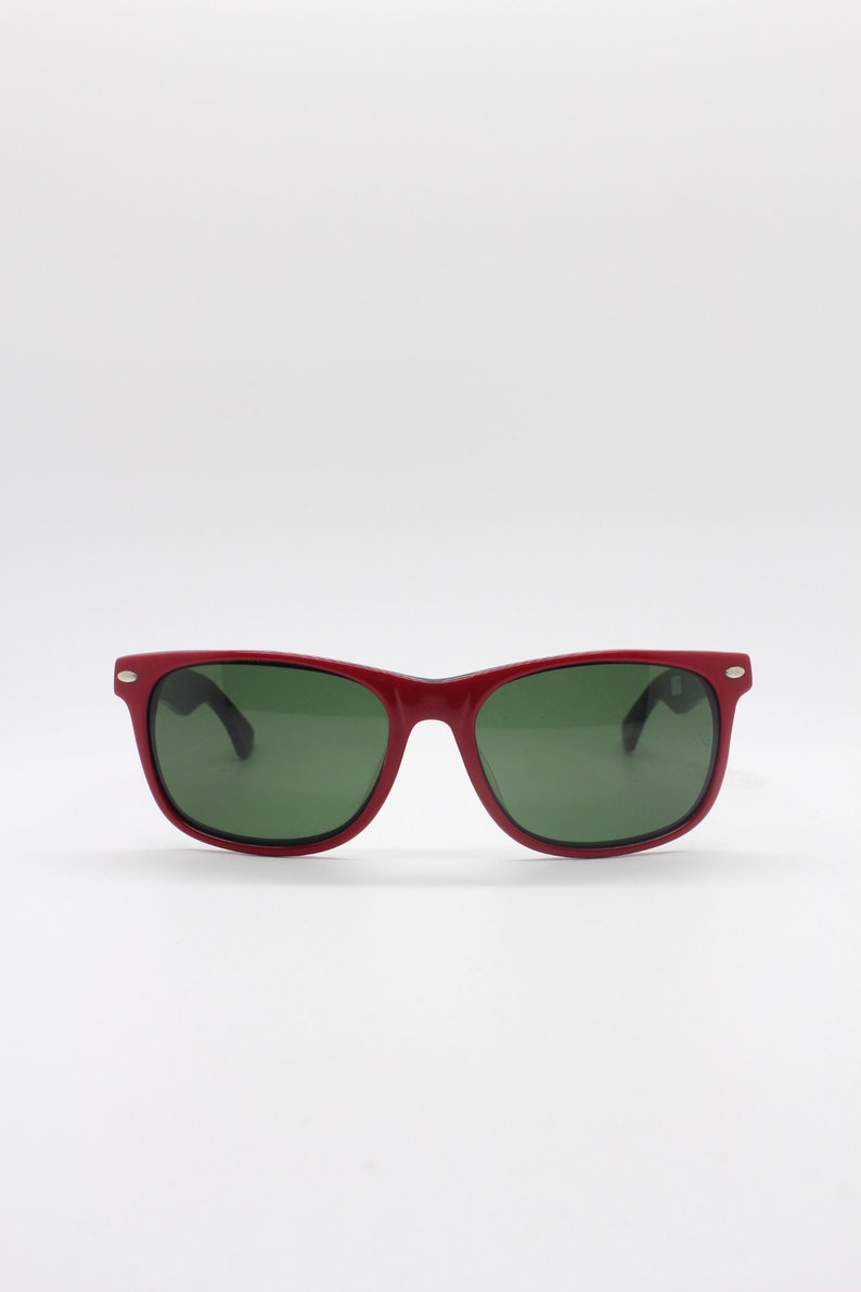 May include: Red plastic sunglasses with green lenses.