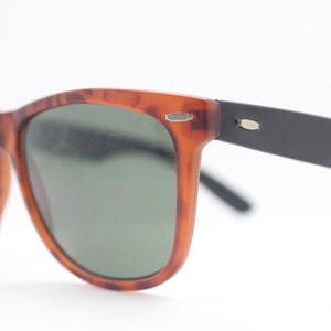 80s vintage wayfarer style sunglasses. Tortoise matt frame with black arms and green lenses. Unused NOS