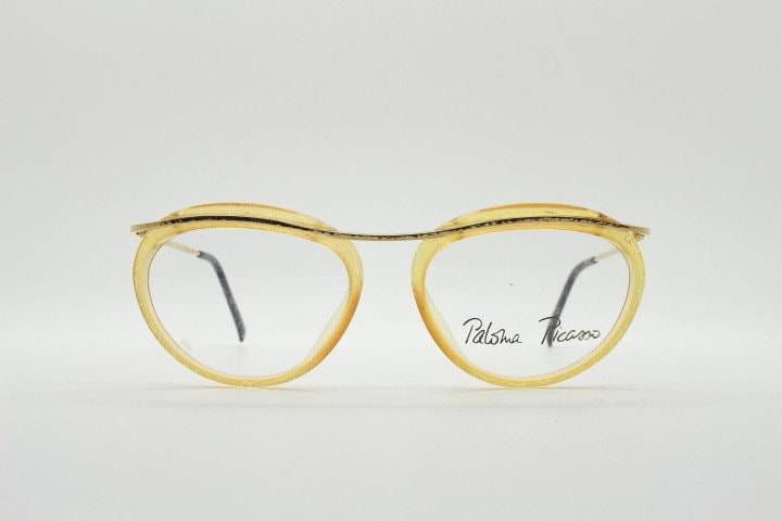Paloma Picasso vintage 80s oval eye glasses made in Germany. Transparent beige acetate optical frame on golden metal brow. Prescription NOS