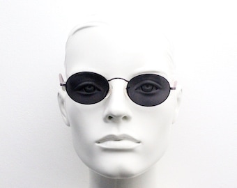 May include: A white mannequin head wearing round, black sunglasses with a thin, silver frame.
