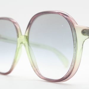 Occhiali da sole oversize rotondi da donna vintage anni &#39;70, realizzati in Italia. Lenti in vero vetro fumé chiaro su montatura trasparente multicolore. Mod