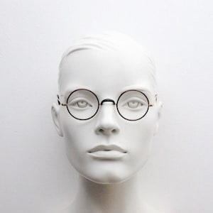 Round 30s vintage eye glasses. Brown lens surrounds on a gold Windsor optical frame. Antique prescription eyeglasses. 20s