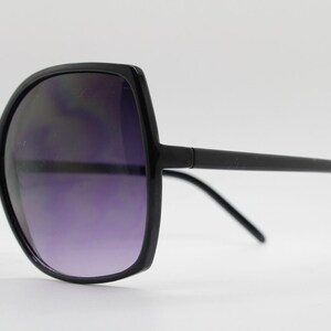 Puede incluir: Gafas de sol negras de gran tama&ntilde;o con montura cuadrada y lentes oscuras.