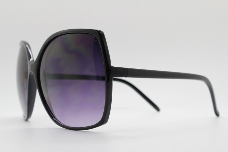Puede incluir: Gafas de sol negras de gran tama&ntilde;o con montura cuadrada y lentes oscuras.